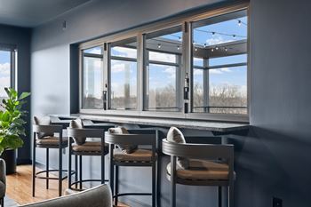 a bar with chairs and a window with a view
